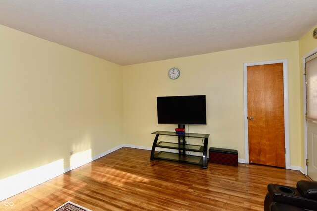 living room featuring a textured ceiling and dark hardwood / wood-style floors