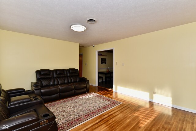 living room with a textured ceiling and wood-type flooring