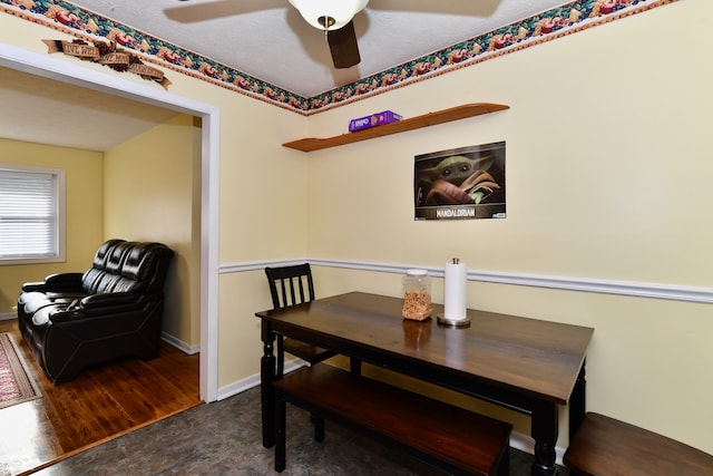 dining area with dark wood-type flooring, ceiling fan, and a textured ceiling