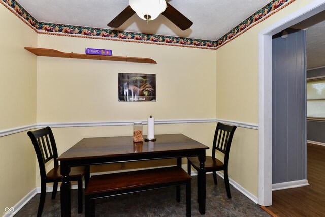 dining space featuring a textured ceiling, ceiling fan, and dark hardwood / wood-style flooring