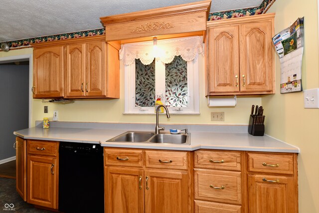 kitchen featuring black dishwasher, sink, and a textured ceiling