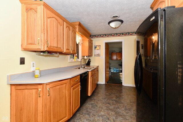 kitchen featuring black appliances, a textured ceiling, and sink