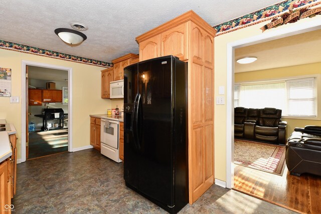 kitchen featuring a textured ceiling, dark wood-type flooring, and white appliances