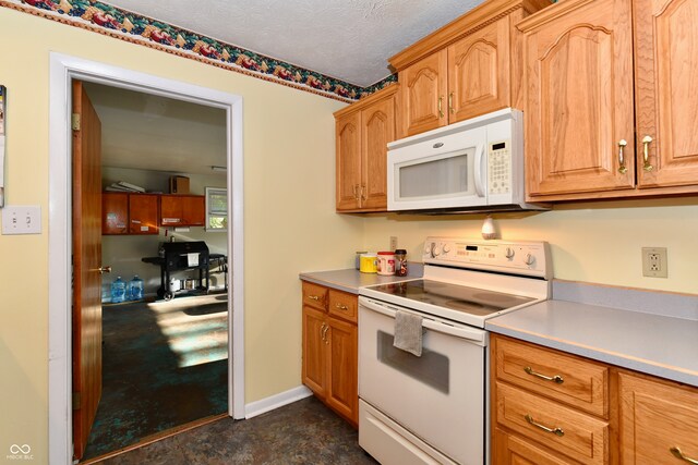 kitchen with a textured ceiling and white appliances