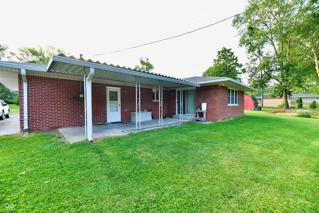 back of property featuring a yard and brick siding