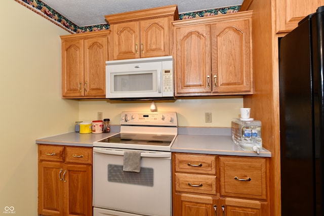 kitchen featuring white appliances and a textured ceiling