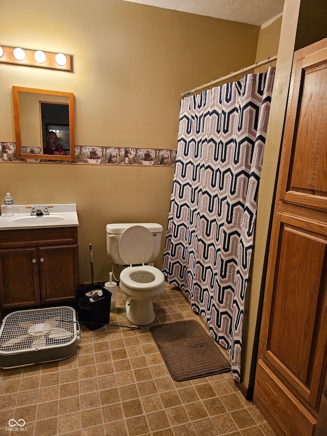 bathroom featuring a shower with shower curtain, toilet, a textured ceiling, and vanity