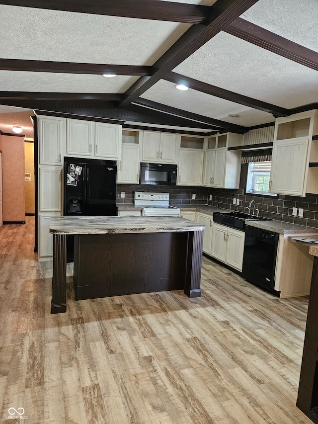 kitchen with black appliances, sink, vaulted ceiling with beams, and a kitchen island