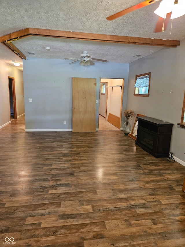 unfurnished living room featuring ceiling fan, dark hardwood / wood-style floors, and a textured ceiling