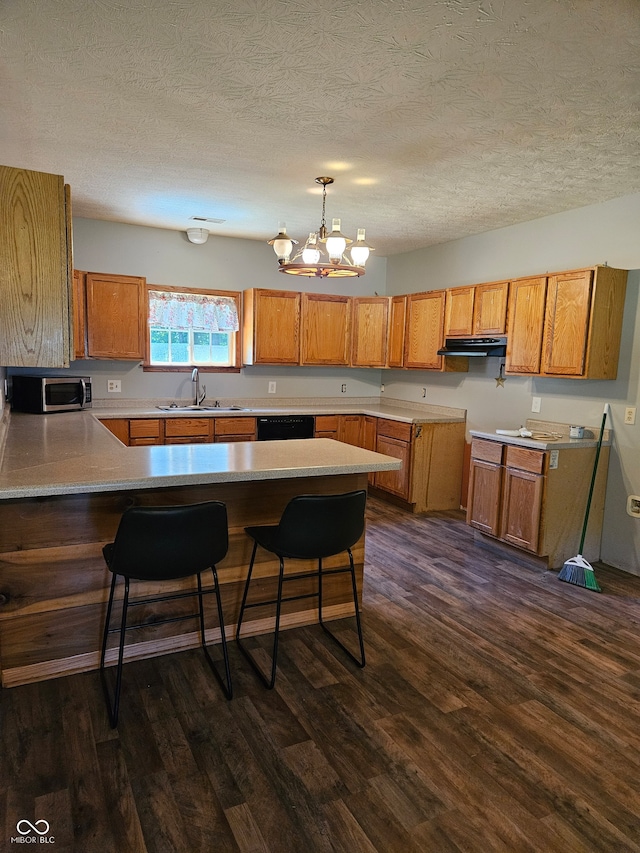 kitchen featuring an inviting chandelier, dark hardwood / wood-style flooring, kitchen peninsula, a breakfast bar, and a textured ceiling