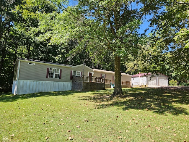 view of yard featuring a garage, a deck, and an outbuilding