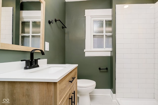 bathroom featuring tile patterned flooring, vanity, toilet, and a shower