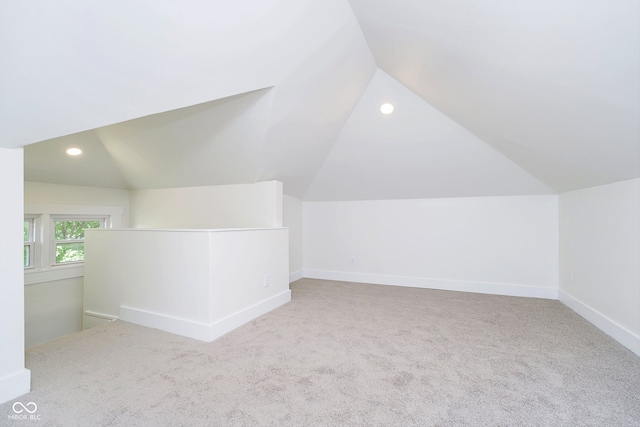 bonus room featuring lofted ceiling and light carpet