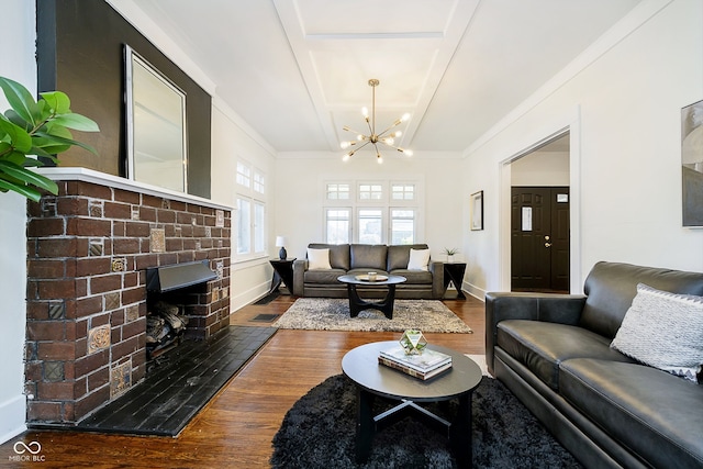 living room with a fireplace, dark hardwood / wood-style floors, a chandelier, and ornamental molding