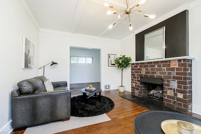 living room with an inviting chandelier, hardwood / wood-style flooring, and a fireplace