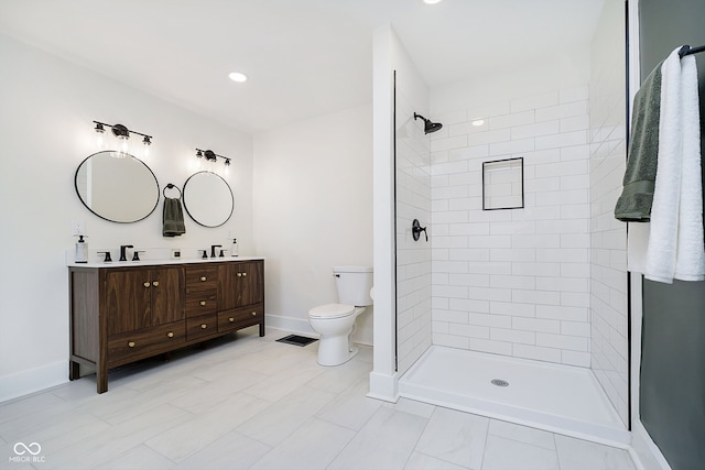 bathroom featuring tiled shower, vanity, and toilet