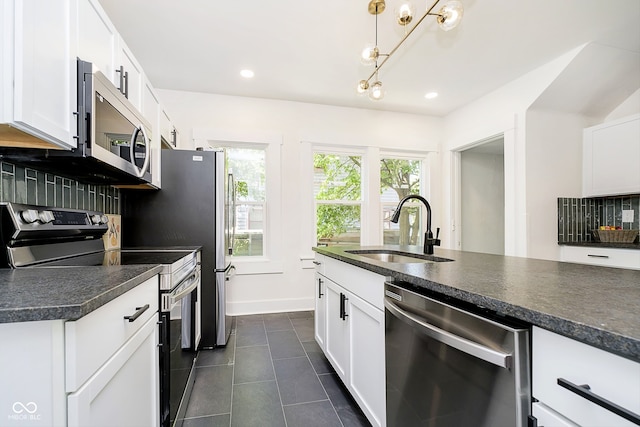 kitchen featuring white cabinets, appliances with stainless steel finishes, sink, and decorative backsplash