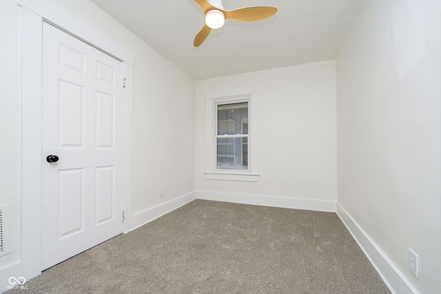 carpeted spare room featuring ceiling fan