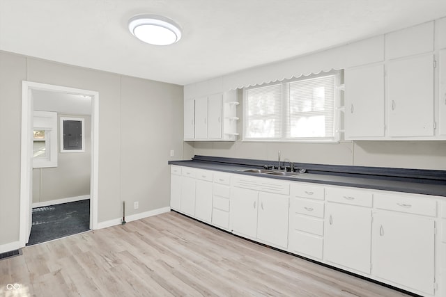 kitchen featuring white cabinetry, light hardwood / wood-style flooring, and sink