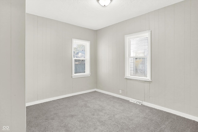 unfurnished room featuring a textured ceiling and carpet