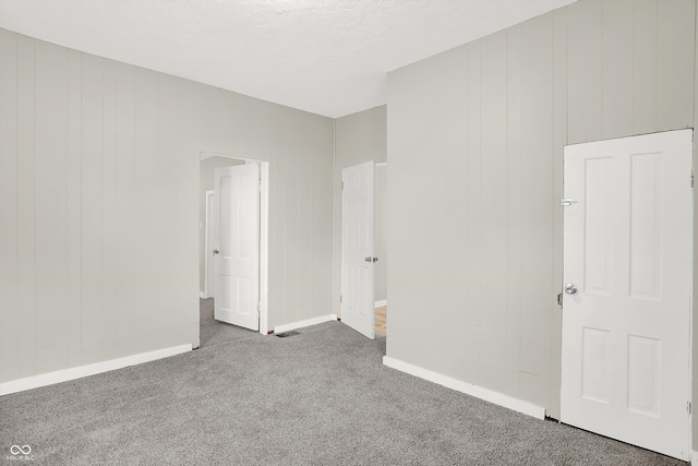 unfurnished bedroom featuring a textured ceiling and carpet