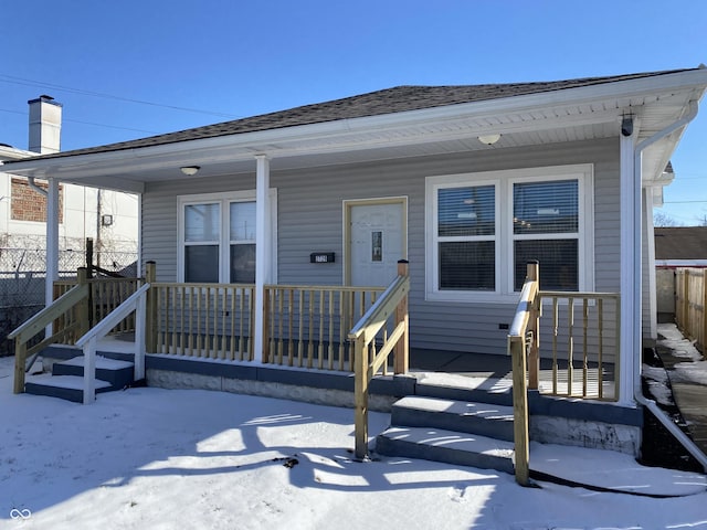 view of front of house featuring a porch, roof with shingles, and fence