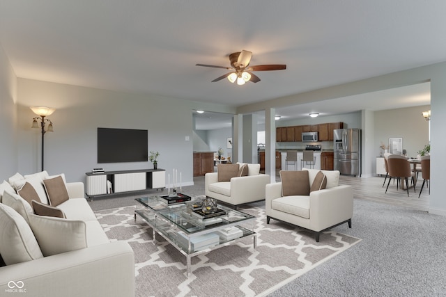 carpeted living room featuring ceiling fan