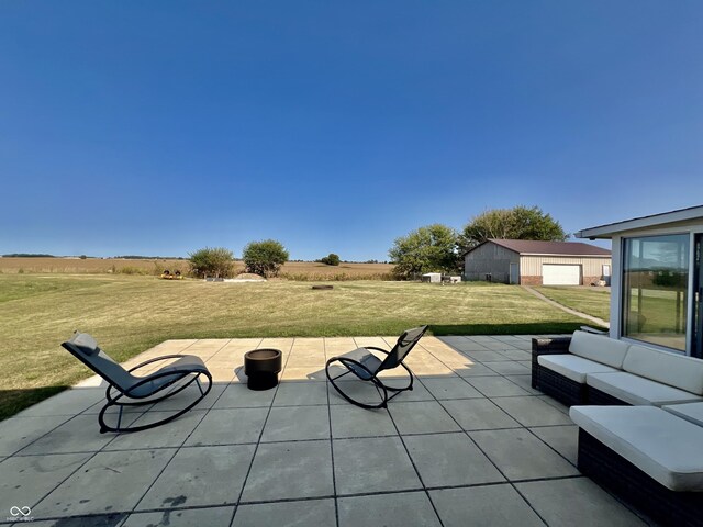 view of patio with a rural view, a garage, and an outdoor structure