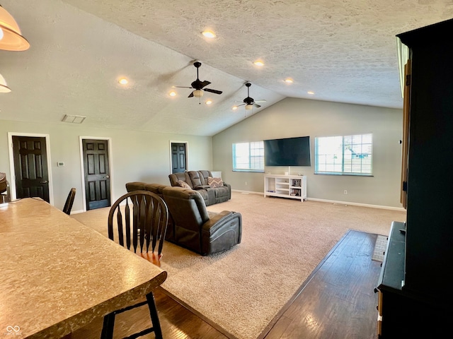 living room featuring a textured ceiling, ceiling fan, hardwood / wood-style floors, and vaulted ceiling