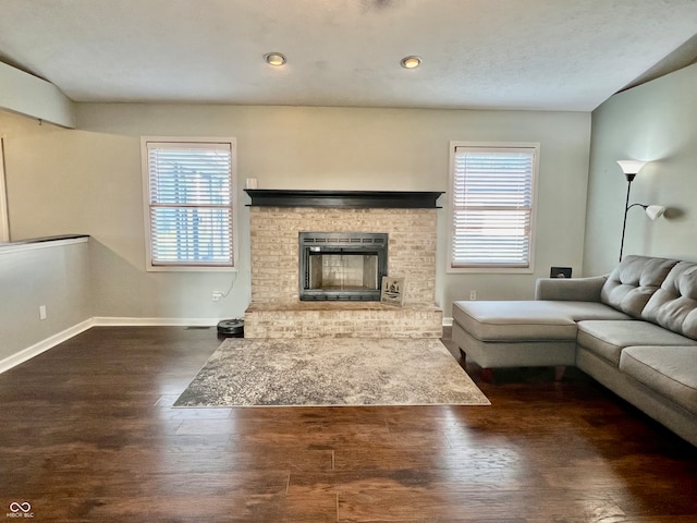 unfurnished living room with dark hardwood / wood-style floors and a brick fireplace