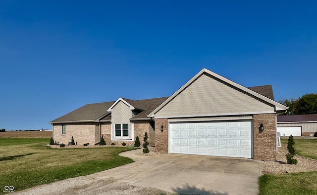 view of front of house featuring a front lawn, a garage, brick siding, and driveway