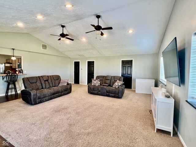 carpeted living room with a textured ceiling, ceiling fan, and lofted ceiling