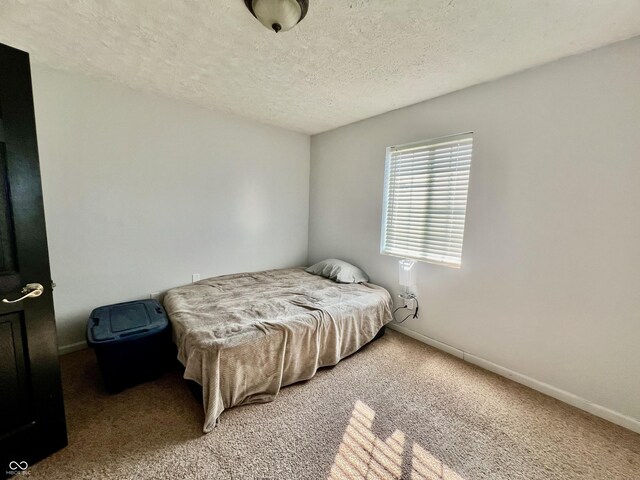 bedroom featuring carpet flooring and a textured ceiling