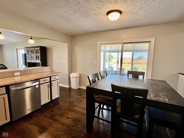 dining room featuring dark wood-type flooring and a textured ceiling