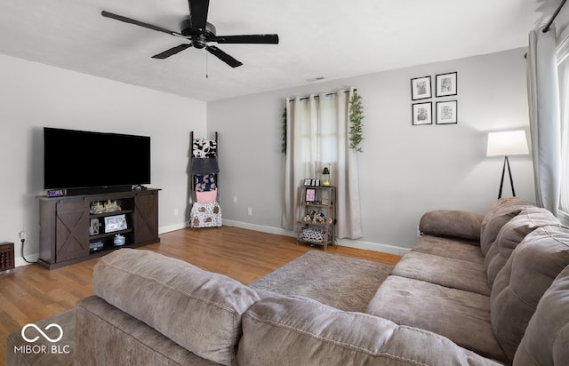 living room featuring light hardwood / wood-style flooring and ceiling fan