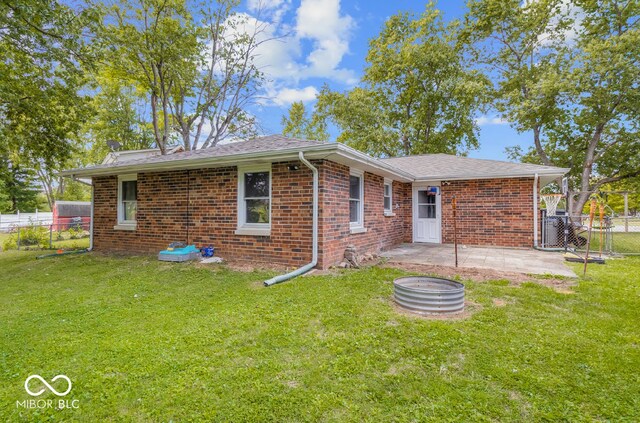 view of front facade with a fire pit, a front yard, and a patio area