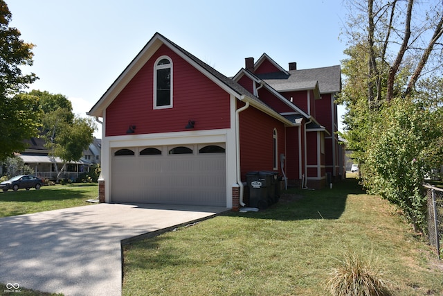 view of side of home featuring a garage and a lawn