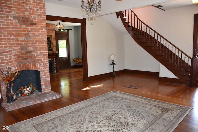 living room featuring a fireplace, an inviting chandelier, and dark hardwood / wood-style flooring