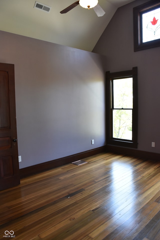 empty room with lofted ceiling, ceiling fan, and dark wood-type flooring