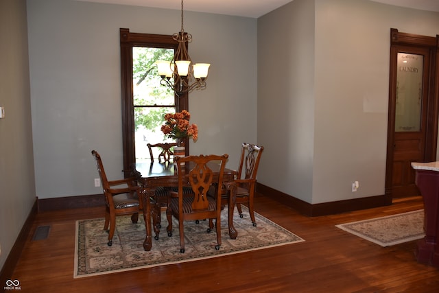 dining area featuring a chandelier and dark wood-type flooring