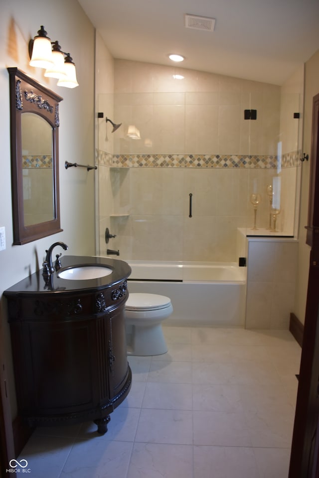 full bathroom with vaulted ceiling, tiled shower / bath, vanity, and toilet