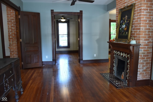 living room featuring ceiling fan, a fireplace, and dark hardwood / wood-style flooring