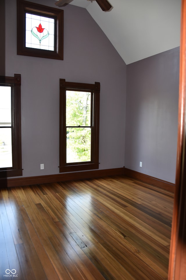 empty room featuring vaulted ceiling, dark wood-type flooring, and ceiling fan