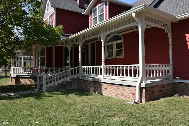 view of side of property with a yard and covered porch