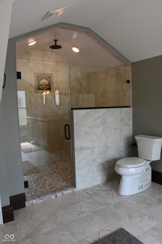 bathroom with lofted ceiling, a shower with shower door, and toilet