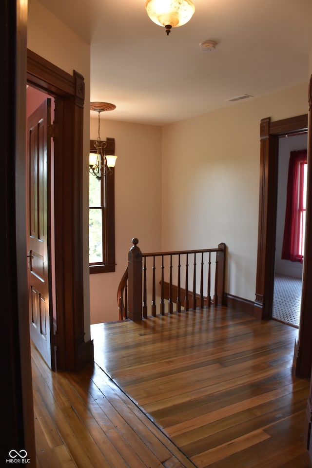 hallway with a chandelier and dark hardwood / wood-style flooring