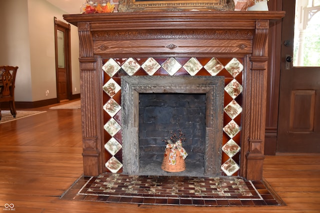 room details featuring a tiled fireplace and hardwood / wood-style floors