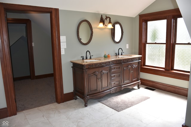 bathroom with lofted ceiling, vanity, a chandelier, and a wealth of natural light