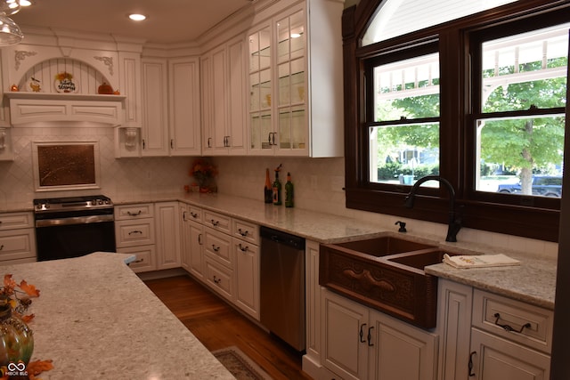 kitchen with dark wood-type flooring, sink, white cabinets, appliances with stainless steel finishes, and light stone countertops