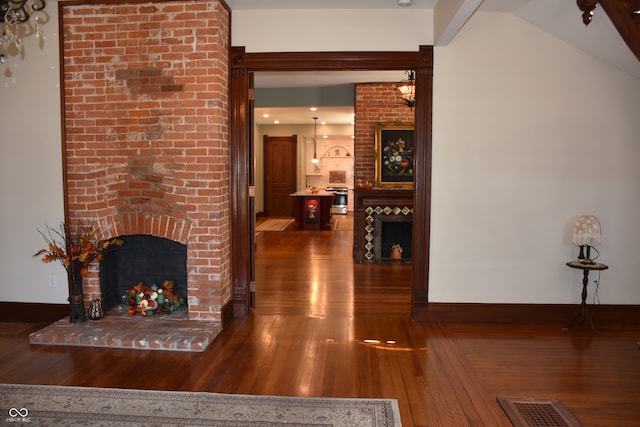 hallway featuring vaulted ceiling and dark hardwood / wood-style floors